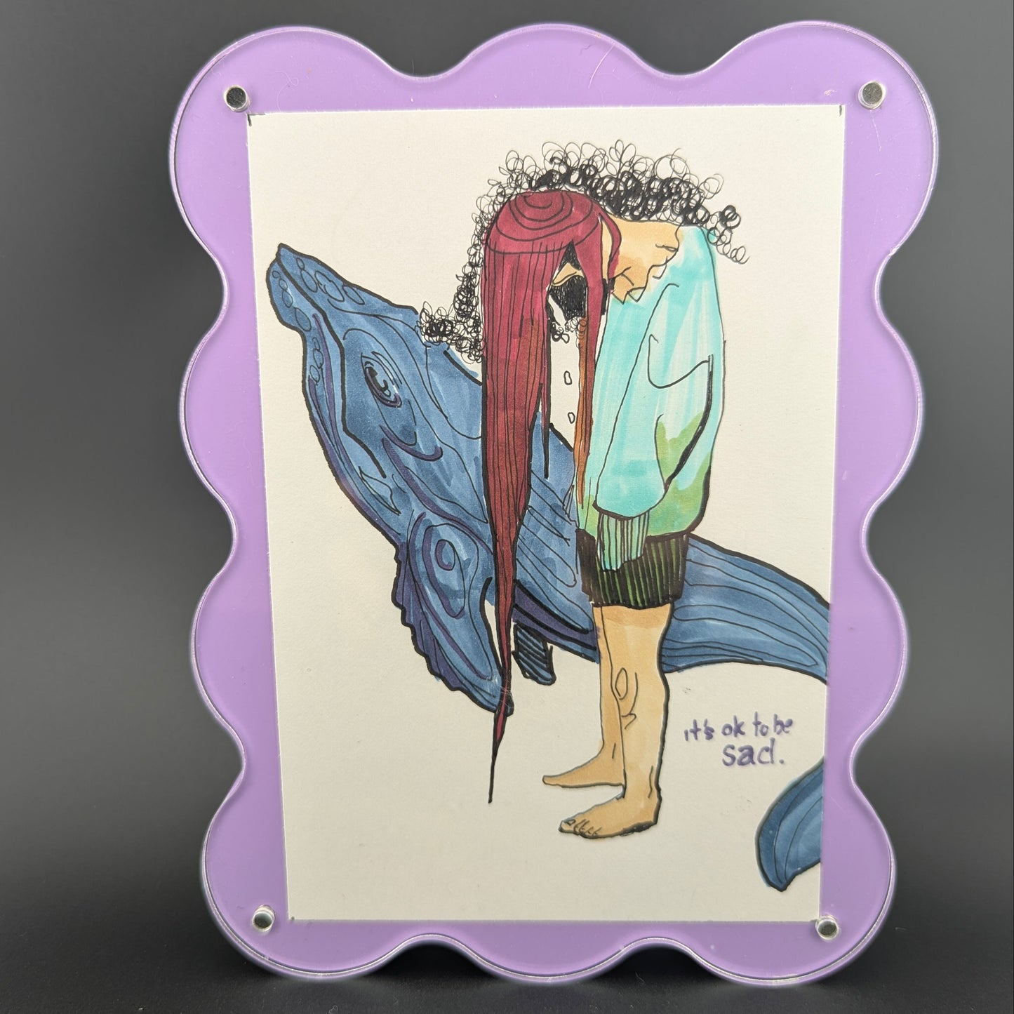 Illustration of a person with red hair embracing a whale, framed in purple on a dark background