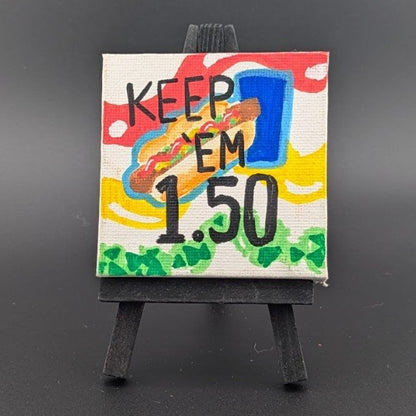 Small painting on a mini easel with text and colorful design on a gray background