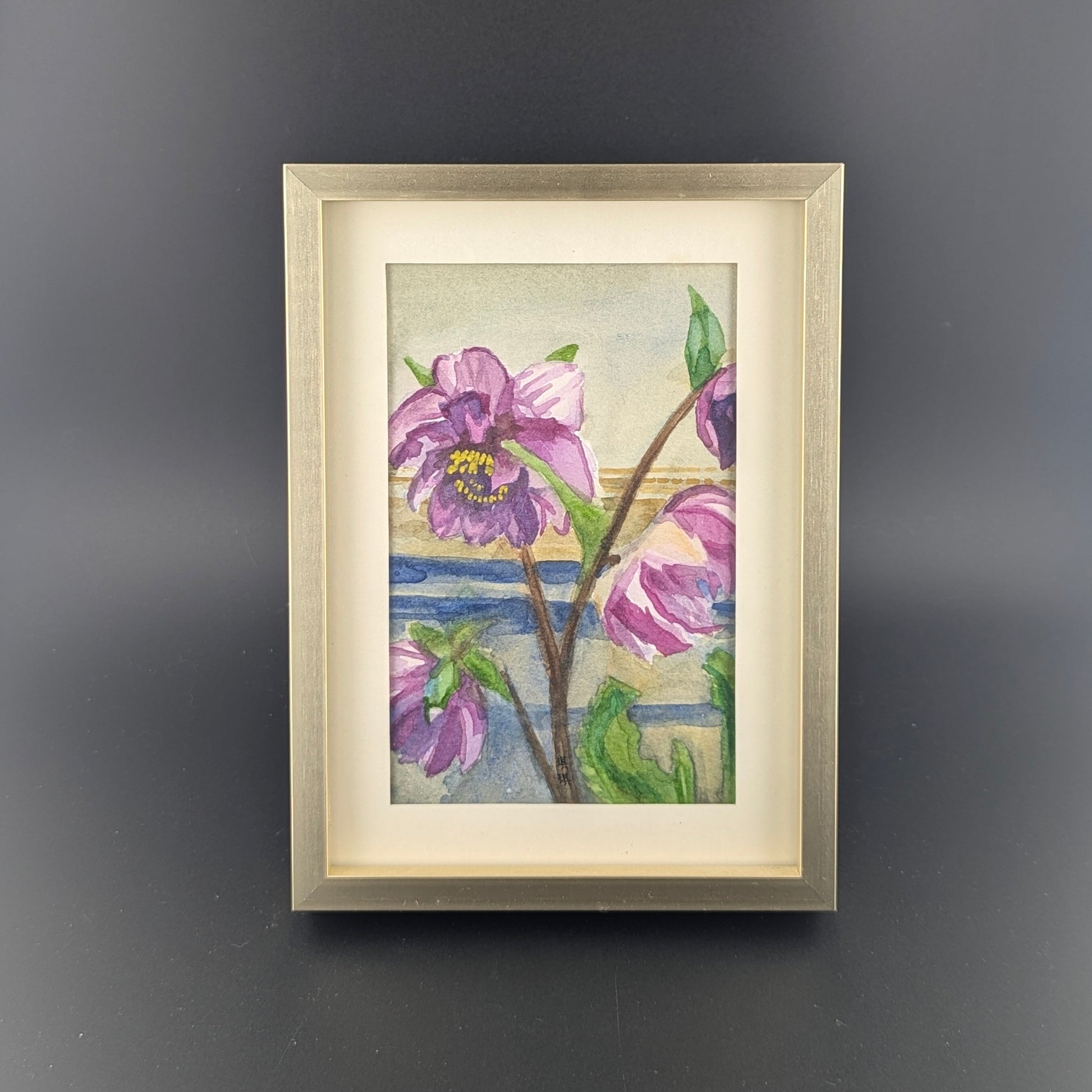 Framed artwork of purple flowers on a dark gray background