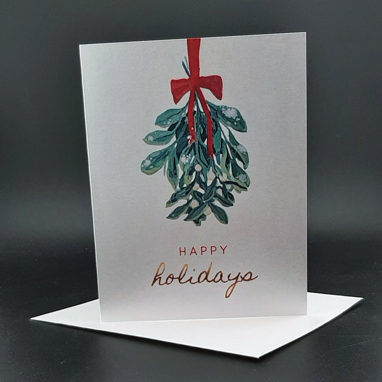 Greeting card with mistletoe design and 'Happy holidays' text on a dark background