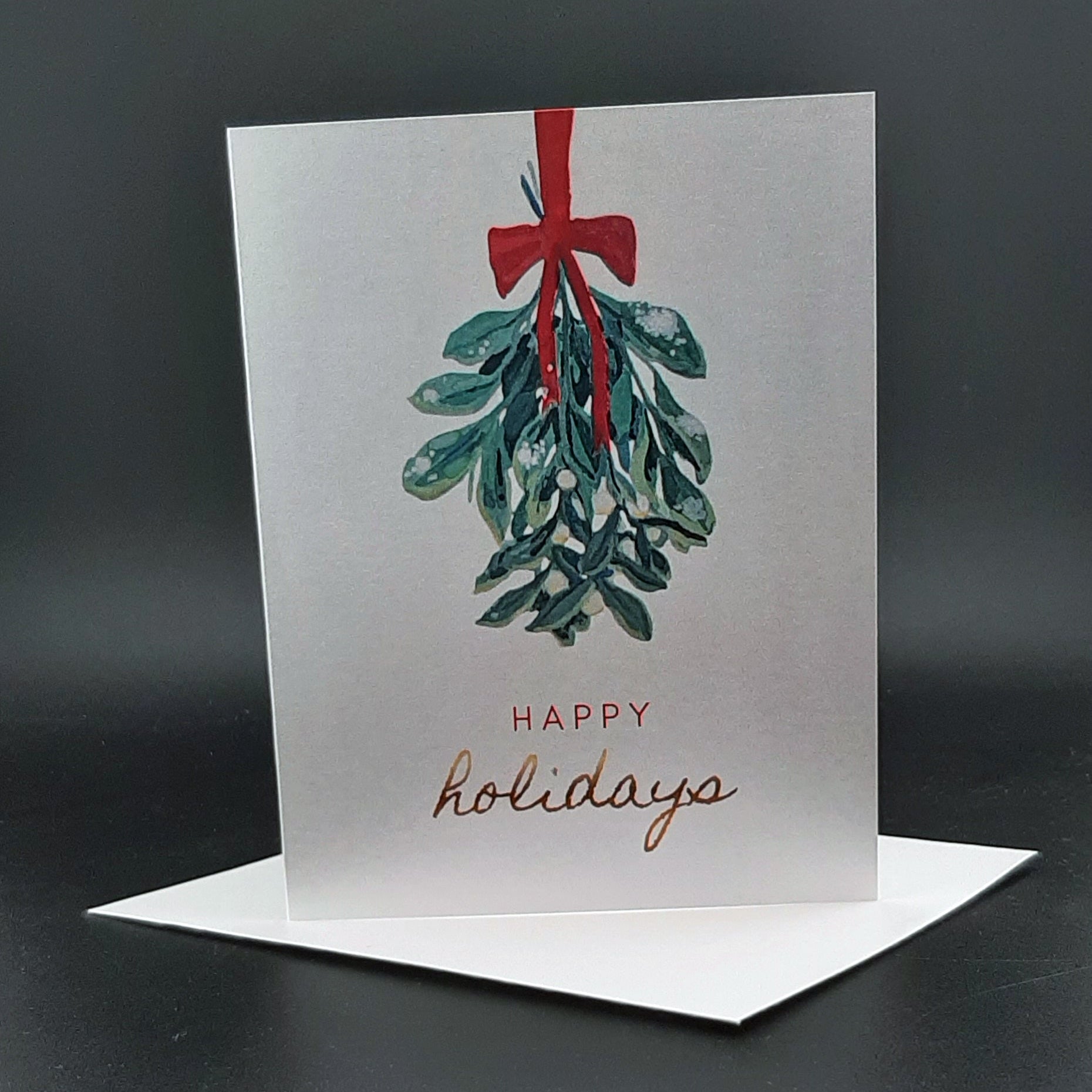 Greeting card with mistletoe design and 'Happy holidays' text on a dark background